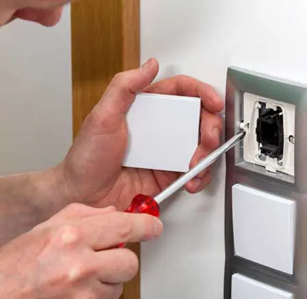 Electrician installing a light switch cover.